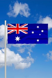 National flag of Australia, in front of cumulus clouds and blue sky, studio