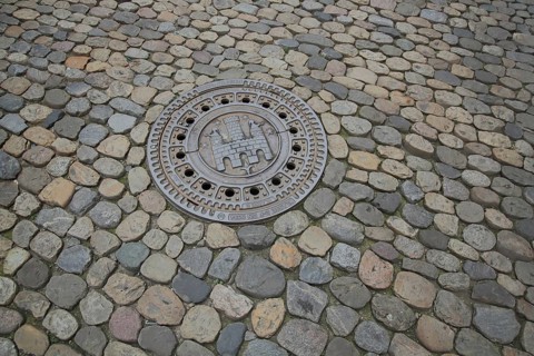 Manhole cover with city coat of arms, paving stones, soil, Freiburg, Breisgau, Southern Black