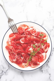 Plate with sliced cured meat, pork neck, prosciutto coppa, Italian delicacy