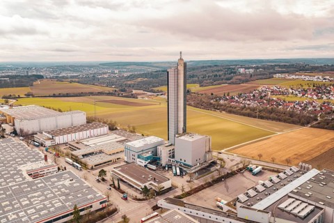 Tall tower building in an industrial and agricultural landscape with villages in the background,