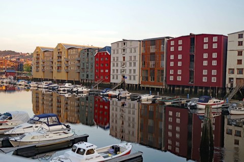 Colourful houses and boats are reflected in the calm harbor water in a peaceful evening mood,