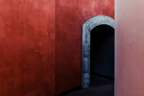 This image features a minimalist architectural design with a striking contrast between vibrant red