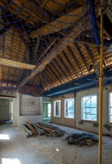 Interior view of an abandoned building under renovation. Scaffolding and construction materials are