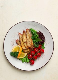 Fried Tilapia fish fillet, in spices, with cherry and salad, on a white plate, homemade, no people