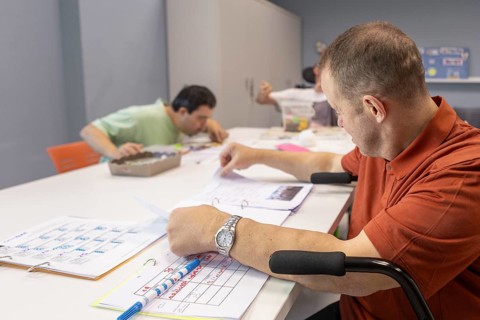 People at a day center for individuals with disabilities are engaged in activities. They are