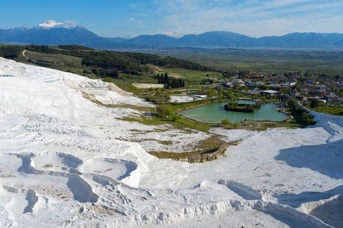 Panorama of travertine terraces with landscape and water basin in the background, sinter terraces,