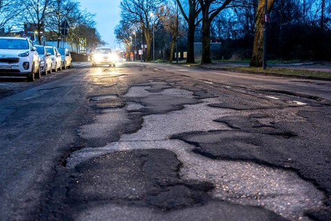 Many large potholes on an inner-city road, Lange Straße in Krefeld-Uerdingen, the heavily