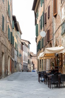 Small shopping street in the historic centre of Siena, Tuscany, Italy