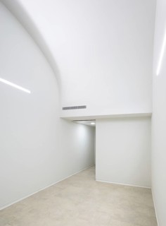 Minimalist interior of hospital featuring a smooth curved ceiling and ample white space. Neutral