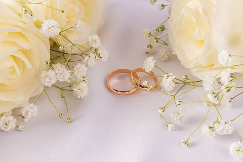 A stunning arrangement of elegant wedding rings surrounded by delicate white flowers and creamy