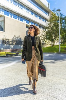 Vertical photo of a modern arab entrepreneur walking confident along city