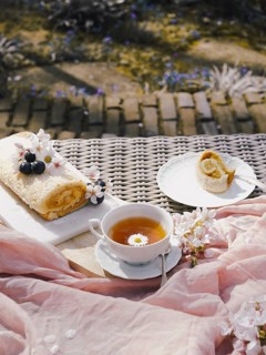 A delectable Swiss roll filled with rich dulce de leche, presented on a garden table, accompanied