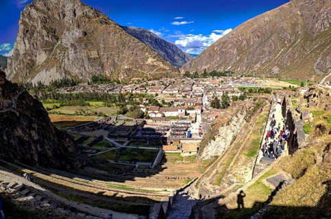 Valley village with mountain scenery and tourists, traditional architecture, sweeping views, the