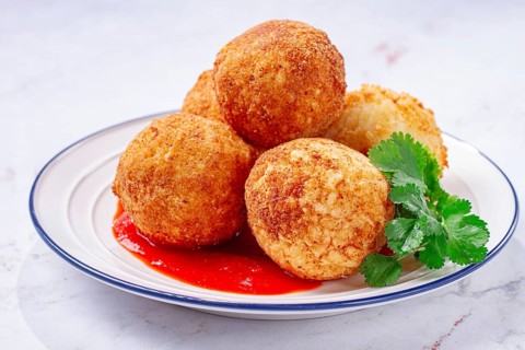 Arancini appetizer with tomato sauce, on a white plate, homemade, no people