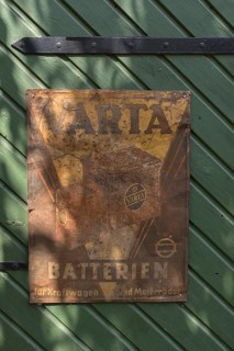 Old rusted tin sign from Varta Batterien on a stable door, Bavaria, Germany