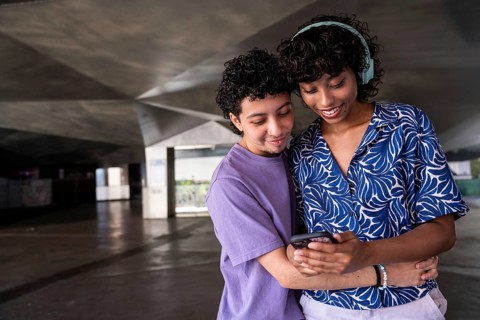 A joyful multiethnic LGBTQ+ couple sharing a tender moment. They embrace and look at something