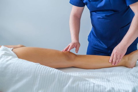 A woman enjoys a calming leg calf massage performed by a skilled therapist, promoting relaxation