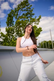 Confident beauty caucasian young woman dancing freestyle urban music in a urban park