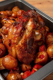 Pork knuckle, baked with vegetables, new potatoes, on a baking sheet, homemade, no people