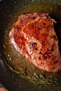 Fried steak, beef steak, rib eye steak, in a frying pan, top view, no people