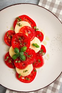 Caprese salad, Italian traditional dish, tomatoes with mozzarella cheese, basil and spices, top