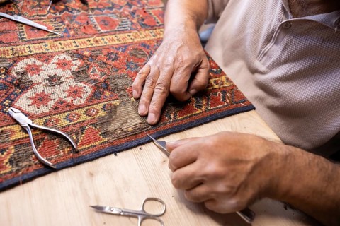 Cropped unrecognizable Iranian master demonstrates his rare skill by meticulously restoring an old,