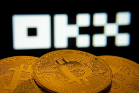 Dhaka, Bangladesh- 04 April 2025: Close-up of Bitcoin coins with the OKX logo visible on a screen