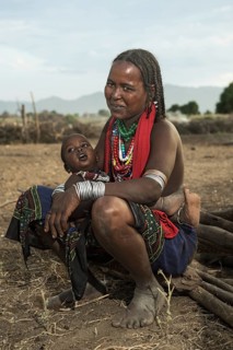 Ethnic group of the Arbore: Sitting woman with baby, wearing jewellery made of colourful bead