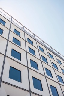 Modern architectural building facade with square windows under a clear blue sky. The image