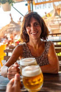 Toast of a couple on the beach in summer drinking a few beers on summer vacation