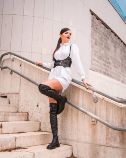 Young caucasian girl with white shirt and black leather boots. Enjoying the holidays in the city,