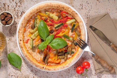 Mouthwatering vegetarian pizza topped with zucchini, eggplant, bell peppers, and olives. Fresh