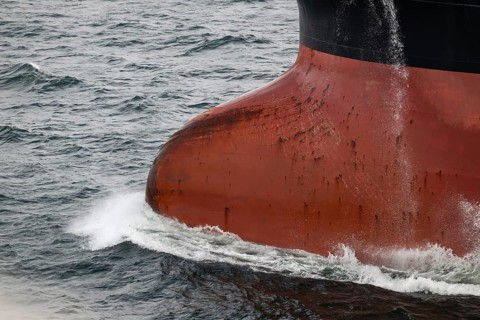 Close-up, bow of a tanker ship cuts through the sea and produces spray, overseas port, Rostock,