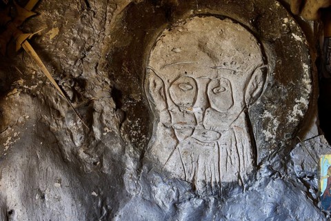 Face carved into the cave wall in the form of a stone relief, chapel, Agios Nikolaos, rock chapel,