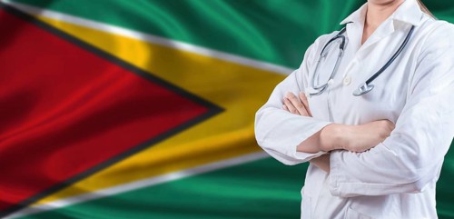 Doctor with crossed arms on Guyana flag. Guyanese health and care concept. Female doctor on Guyana