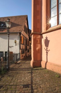 Narrow alley between Glöcknerhaus and city church with reflection of the sun, Michelstadt,