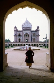 Frau geht durch den Torbogen in Richtung Safdarjung-Grabmal, erbaut 1754, Mughal-Architektur,