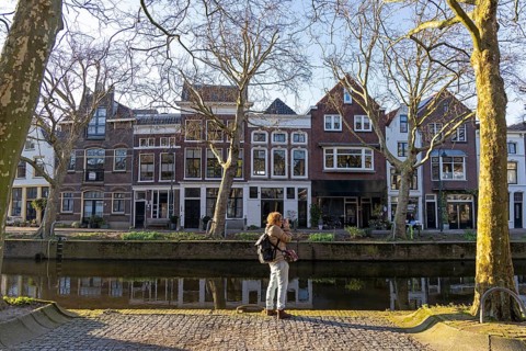 Houses on the river Binnengouwe, woman photographed, Gouda, Holland, Netherlands