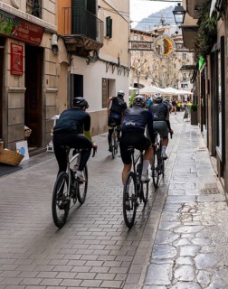 Group of racing cyclists in a narrow alley, Soller, Majorca, Balearic Islands