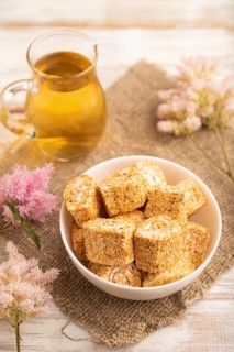 Traditional turkish delight (rahat lokum) in white ceramic plate with glass of green tea on a white