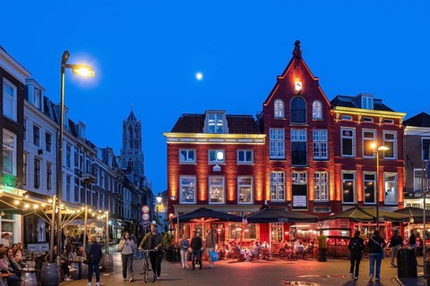 Nightlife at De Neude square in the background the bell tower of the cathedral in the historic
