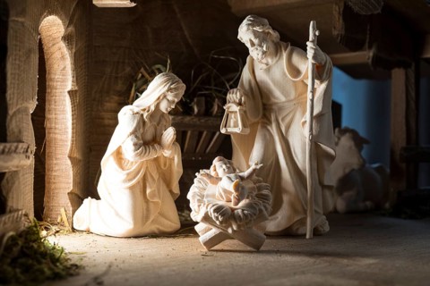 The Holy Family at the crib, wooden crib figurines represent the birth of Jesus Christ Child lying