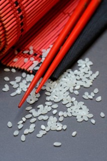 Rice, white rice grains and chopsticks with bamboo mat