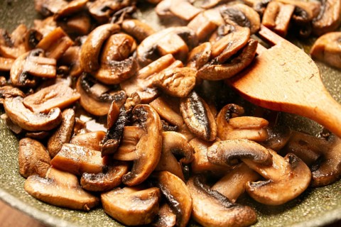 Fried mushrooms in a frying pan, with a wooden fork, homemade, no people