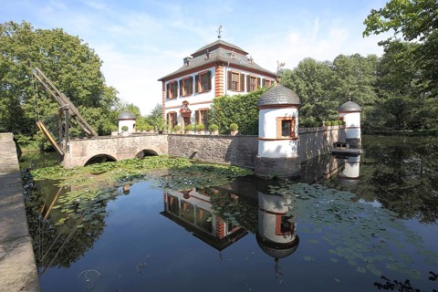 Moated castle built around 1703 with drawbridge, pond, reflection, Seligenstadt, Hesse, Germany
