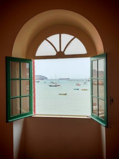 View of the sea through an open window with boats in a quiet atmosphere, Torre de Belem, Mindelo,