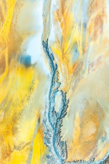 A mesmerizing aerial view capturing intricate fractal patterns in mud, highlighted with vivid blue