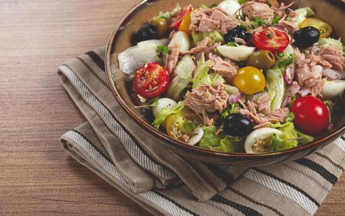 Salad with canned tuna, vegetable salad with quail eggs, lettuce, red onion, cherry tomatoes,