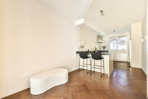 Contemporary kitchen featuring a sleek design with black counter tops. Bar stools provide casual