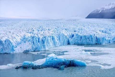 Perito Moreno glacier with glowing blue ice front, Lake Argentino surrounded by snow-capped